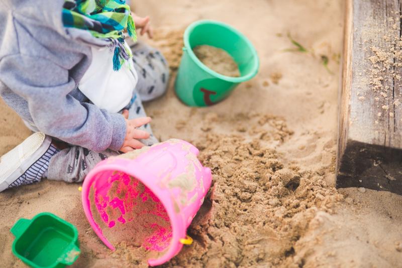 Toddler playing in a sandbox